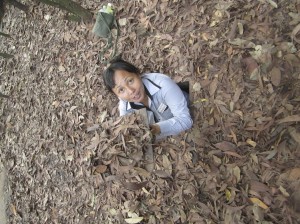 Mai crawls through a hidden entrance to the Cu Chi Tunnels.